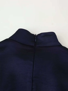 Gros plan détaillé du col montant et de la fermeture éclair invisible sur robe en satin bleu