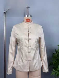 Detailed close-up of beige oriental style jacket with traditional frog buttons