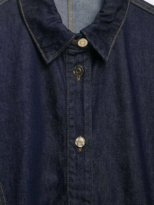 Detail of dark blue denim jacket with contrast yellow stitching and vintage buttons
