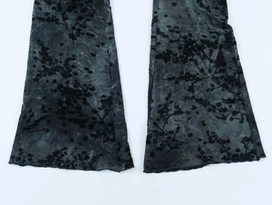 Dettaglio ravvicinato della floccatura floreale nera su tessuto mesh dei pantaloni