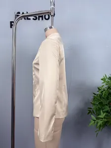 Detail of apricot satin blazer featuring sleek mandarin collar and glossy finish fabric