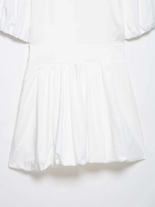 Detailed close-up of the waist pleats and crisp woven fabric on this white puff sleeve dress