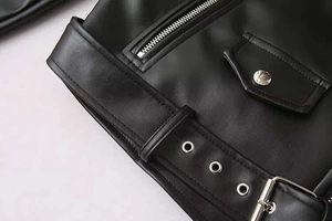 Détails de la veste en cuir avec ceinture à boucle argentée et poches zippées