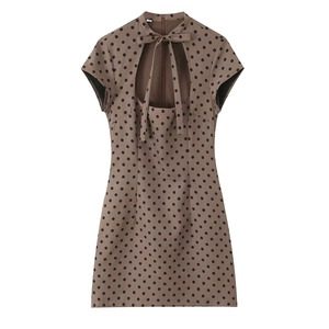 Detailed view of brown polka dot mini dress featuring a bow-tie neckline and size M tag