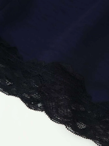 Vue détaillée de l'ourlet de robe bleu marine avec dentelle noire délicate brodée