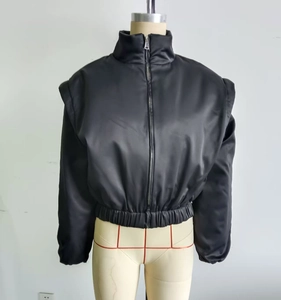 Detail der schwarzen kurzen Stehkragenjacke mit Satin-Finish und Schulterpolstern