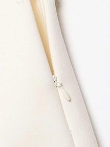 Detailed macro view of the seamless invisible zipper on high waist white skirt