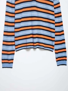 Detail of blue and orange striped knit sweater hem and sleeves on white background