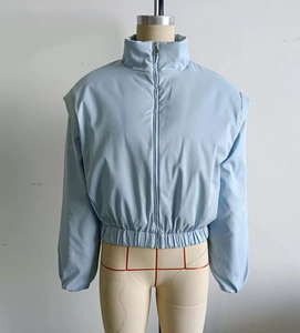 Detailansicht einer hellblauen Steppjacke mit Stehkragen und Reißverschluss auf der Front