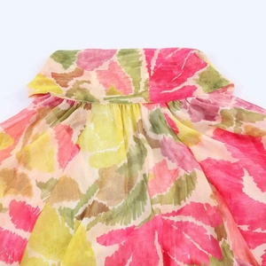 Close-up of floral print chiffon dress with pleated collar details and bright flower pattern