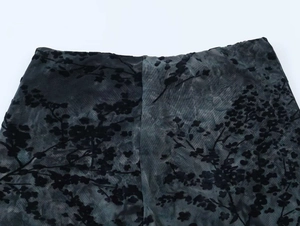 Dettaglio ravvicinato del tessuto mesh grigio-blu scuro con motivi floreali neri