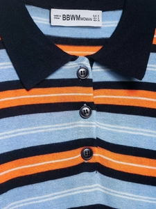 Detailed close-up of navy blue and orange striped knit polo collar with logo label