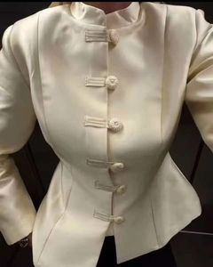 Close-up of ivory satin jacket with traditional mandarin collar and handmade frog buttons