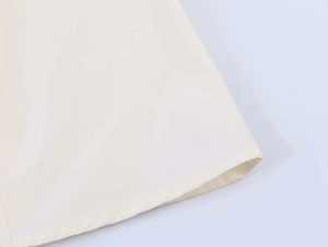 Detailed close-up of ivory short sleeve shirt showing fine stitching and smooth cotton fabric