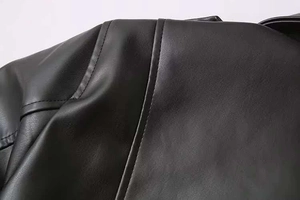 Coutures détaillées sur l'épaule d'une veste vintage en similicuir noir pour femme