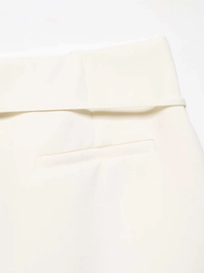Detail of wide waistband and back welt pocket on white high-waisted A-line suit skirt