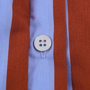 Detailed close-up of striped fabric featuring a white button and vertical twill texture
