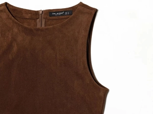 Dettaglio della trama in pelle scamosciata marrone scuro con cerniera nascosta sul retro