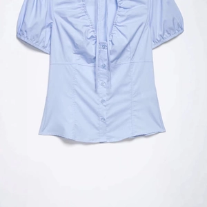Short sleeve light blue poplin blouse with ruched neckline and delicate bow tie detail