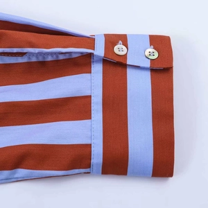 Detailed macro view of striped shirt cuffs with brown and blue patterns and resin buttons