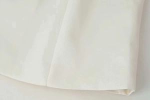 Close-up of white stand-up collar jacket showing premium woven fabric and neat stitching
