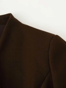 Close-up of shoulder seam and wool blend texture on a dark brown fashion blazer jacket