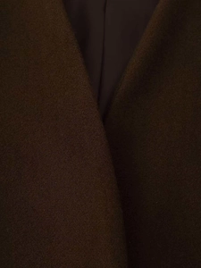 Detailed close-up of dark brown wool coat lapel with premium smooth lining texture