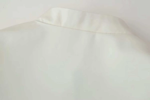 Detailed close-up of the standing collar and seam construction on a white jacket