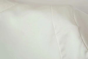 Detailed macro view of high-quality cream white fabric with precision stitching