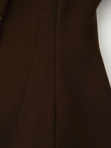 Detailed close-up of dark brown wool fabric texture and vertical tailoring stitching