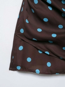 Detailed close-up of dark brown fabric with sky blue polka dots and neat stitching edge