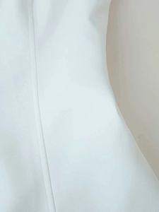 Detailed close-up showing the vertical stitching and fine texture of white fabric top