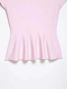 Detailansicht eines rosa Strickoberteils mit tailliertem Schnitt und Schößchensaum