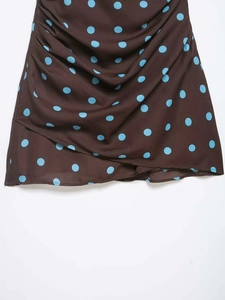 Detail of vintage brown polka dot fabric featuring pleats and sky blue print texture