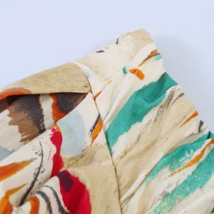 Detailed close-up of vibrant oil painting style abstract print on pleated midi dress