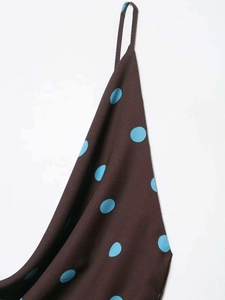 Detail of brown fabric with blue polka dots showing strap and smooth texture