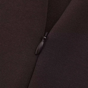 Detail of dark brown knitted fabric featuring a seamless hidden zipper and vertical texture