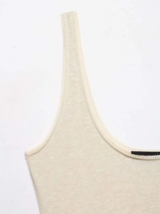 Detail of cream knit camisole neckline featuring delicate scalloped lace trim edges