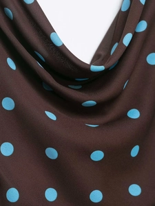 Close-up of vintage brown chiffon fabric featuring bold blue polka dot patterns