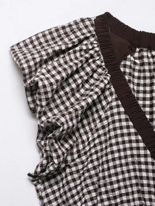 Detailed macro view of brown gingham seersucker fabric with pleated sleeve texture