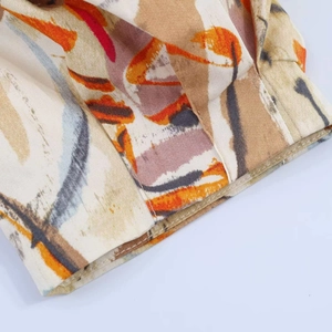 Close-up of puff sleeve detail featuring abstract art print on woven fabric dress
