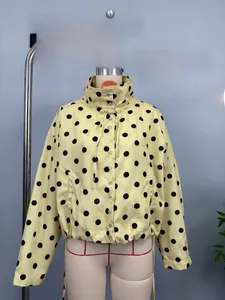 Detail of yellow polka dot jacket showing stand collar and single-breasted buttons