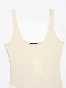 Detail of a beige knit sleeveless dress showing the round neckline and fabric texture