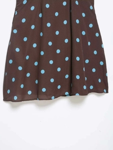 Close-up of brown and blue polka dot fabric texture on lightweight summer dress