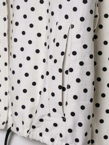 Détail du tissu à pois présentant des poches latérales et un cordon de serrage réglable