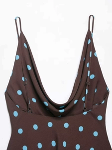 Close-up of brown summer dress with blue polka dots showing V-neckline and fabric texture