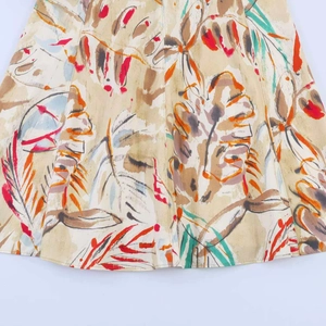 Close-up of tropical leaf print on beige cotton-linen fabric for midi dress