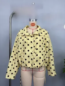 Detail of yellow long sleeve polka dot jacket with black spots and drawstring hem