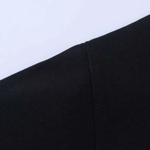 Detail view showing professional double-needle stitching on black lace patchwork T-shirt
