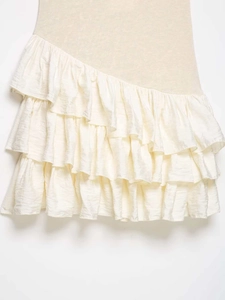 Detail of layered ivory satin ruffles and beige textured fabric on a summer mini dress